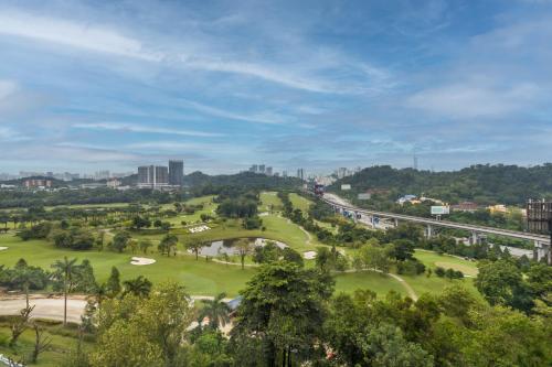 M Resort & Hotel Kuala Lumpur في كوالالمبور: اطلالة على ملعب قولف مع جسر واشجار
