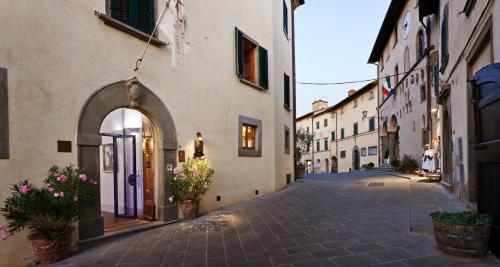 an alley in a town with buildings and flowers at Hotel Palazzo San Niccolò & Spa in Radda in Chianti