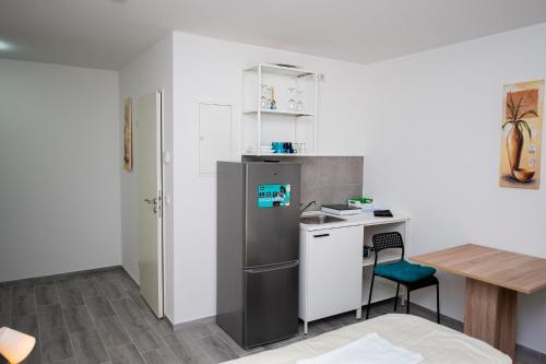 a small kitchen with a refrigerator and a table at Private Studio mit eigene Küche und Bad Netflix Youtube in Nuremberg