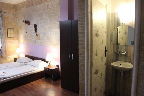 a bedroom with a bed and a sink and a bathroom at Serdika Rooms in Sofia