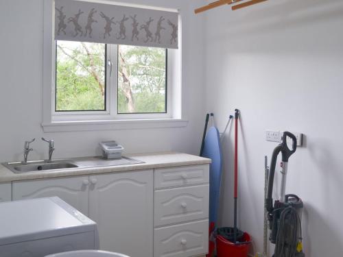 a kitchen with a sink and a window at Tigh Eilidh in Achmelvich