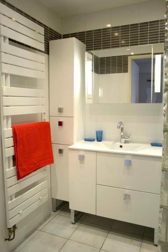 une salle de bain blanche avec un lavabo et un miroir dans l'établissement F3 climatisé-terrasse 30 m2- Parking-Antigone, à Montpellier