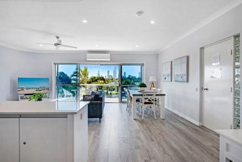 a kitchen and living room with a table and a couch at 3br Broadbeach Lakefront Apartment in Gold Coast
