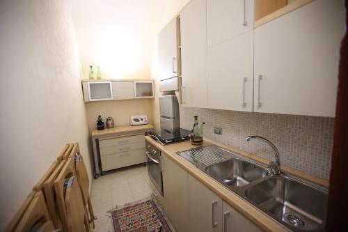 Il comprend une petite cuisine équipée d'un évier et d'une cuisinière. dans l'établissement Bellissimo #1, à Manfredonia