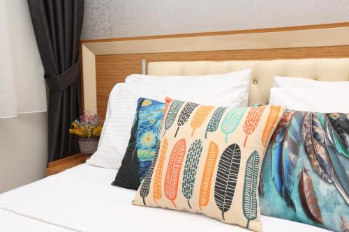Cama con sábanas y almohadas blancas en Perazre Hotel en Estambul