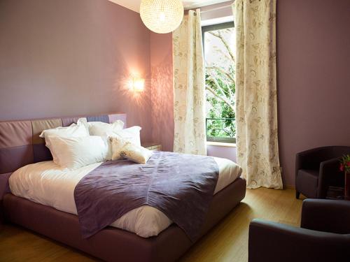 a bedroom with a large bed with a window at Domaine du Prieuré d'Estagel in Saint-Gilles
