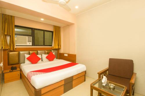 a bedroom with a bed and a desk and a window at OYO Hotel Sarovar Grand in Kalamboli