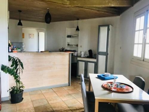 a room with a table and a kitchen with a counter at Chalet PLEINSUD in Le Tampon