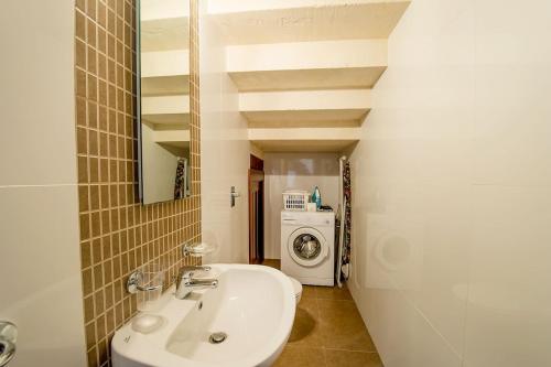 a bathroom with a sink and a washing machine at Hamlet 1 Holiday Home in Għasri