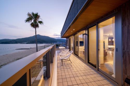 uma casa com uma varanda com vista para a praia em SETOUCHI SUP RESORT - Ao - em Shodoshima