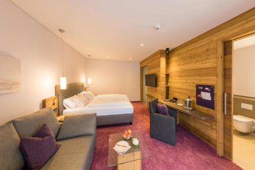 ein Hotelzimmer mit einem Bett und einem Sofa in der Unterkunft Hotel Gasthaus Mosers Blume in Haslach im Kinzigtal