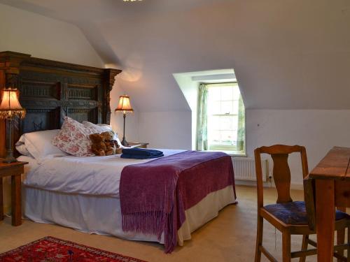 a bedroom with a bed with a teddy bear on it at Avenel Cottage in Town Yetholm