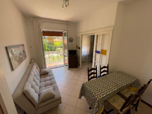 a living room with a couch and a table at Appartamento Note d’estate in Marina dʼAndora