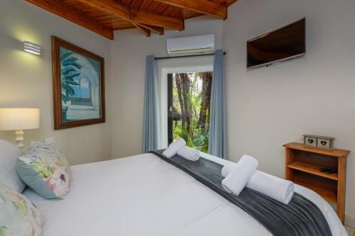 een slaapkamer met een groot wit bed en een raam bij San Lameer Villa 3104 - 3 Bedroom Superior - 6 pax - San Lameer Rental Agency in Southbroom