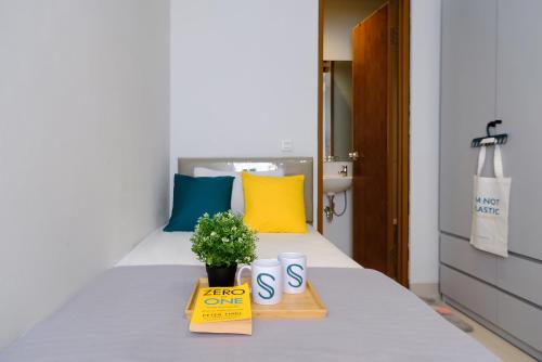 a bedroom with a bed with a sign and a potted plant at TwoSpaces Living at Zena Mozia in Tegal