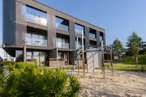 a building with a playground in front of it at VAIVA Apartments, Palanga in Šventoji