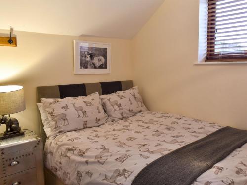 a bedroom with a bed and a lamp on a nightstand at Sparrow - Uk30747 in Acton Trussell