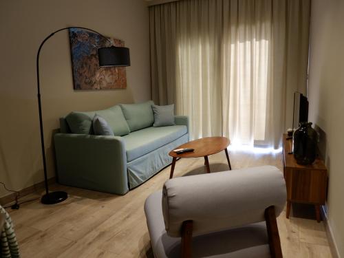 een woonkamer met een bank en een stoel bij Kaiser Luxury Suites in Achílleion