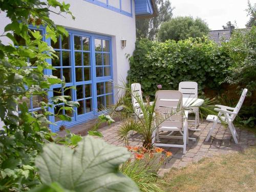 a patio with chairs and a table in a garden at Ferienhaus Diekelmann _ Objekt 258 in Diedrichshagen