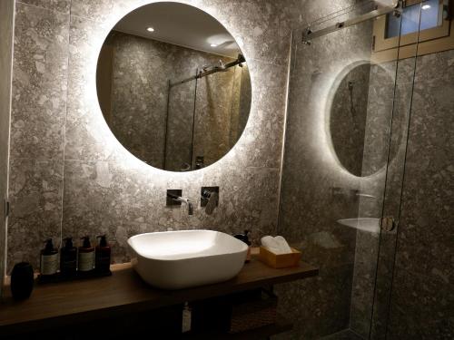 a bathroom with a sink and a mirror at Kaiser Luxury Suites in Achílleion