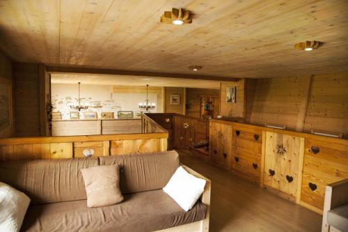 - un salon avec un canapé et des murs en bois dans l'établissement Chalet La Ferme de Noemie, à Mercury