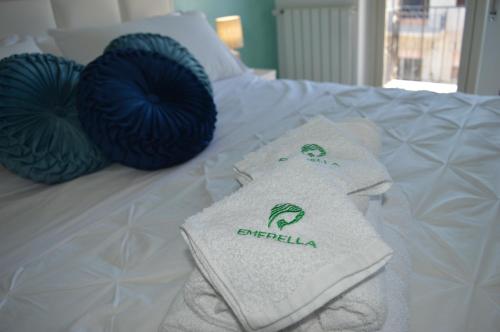 łóżko z 2 poduszkami i ręcznikami w obiekcie Emerella Guest House Siderno Beach w mieście Siderno Marina