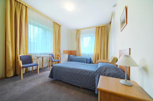 pokój hotelowy z łóżkiem, stołem i krzesłami w obiekcie Perła Bieszczadów - Dom Wczasowy w mieście Czarna