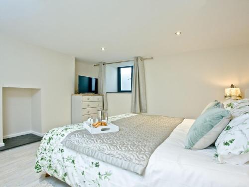 Un dormitorio con una cama blanca y una bandeja. en Bay Tree - Uk13577, en Tavistock
