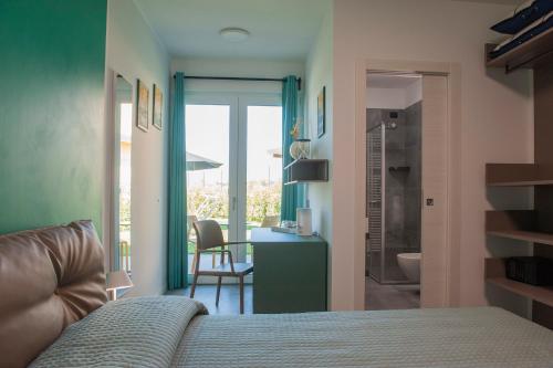 a bedroom with a bed and a desk and a bathroom at B&B Lough in Colà di Lazise