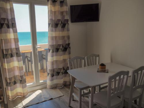 a dining room with a table and a view of the ocean at Superbe appartement vu mer avec parking et Wifi in Le Barcarès