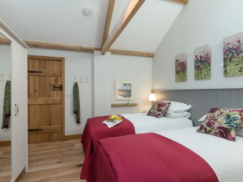a bedroom with two beds with red sheets at Daisy in Scruton