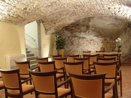 a room with rows of chairs and a stone wall at Hotel Palazzo San Niccolò & Spa in Radda in Chianti