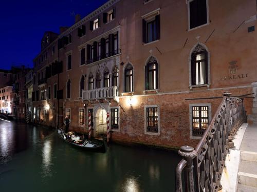 a gondola in a canal in front of a building at Hotel Ai Reali - Small Luxury Hotels of the World in Venice