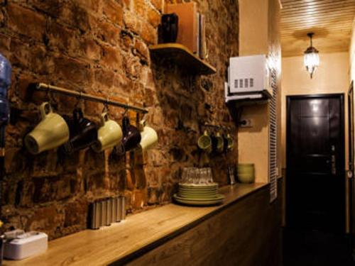 a kitchen with a stone wall with pots and pans at Bonjour Hotel in Saint Petersburg