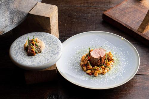 two plates of food on a wooden table at La Ferme Saint Simeon Spa - Relais & Chateaux in Honfleur