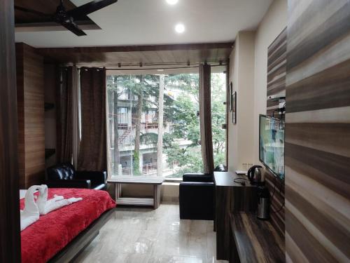 a bedroom with a red bed and a large window at Rana's House, Mcleodganj in McLeod Ganj