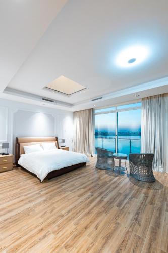 a bedroom with a bed and a view of the ocean at Grande Beach in An Nāmī