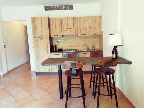 a kitchen with wooden cabinets and a counter with stools at La Casa di Golia in Bagni San Filippo