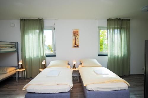 3 Betten in einem Zimmer mit Fenstern in der Unterkunft Neubau für 4 Personen Eigene küche und Bad Netflix Spätere Check in in Nürnberg