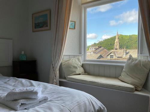 a bedroom with a window with a view of a church at Shambles Cottage in Ambleside