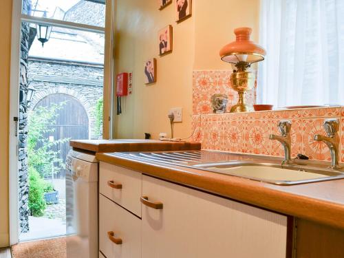 a kitchen with a sink and a window at Shambles Cottage in Ambleside