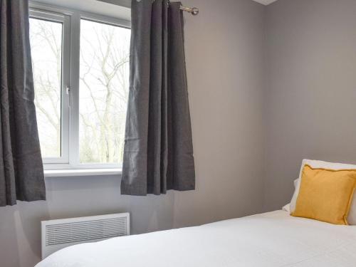 um quarto com uma cama e uma janela em Hare Lodge - Uk30604 em Pidley