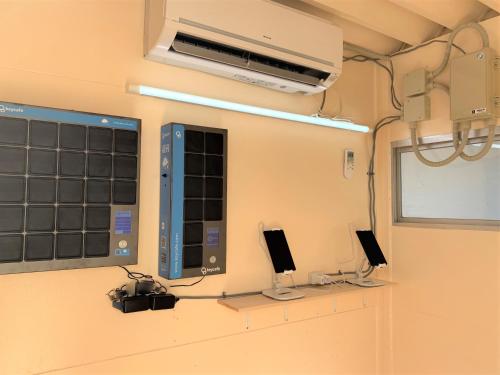 a room with two monitors and a air conditioner at Allstay CHIBANA in Okinawa City