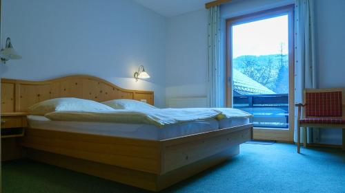 グリューナウ・イム・アルムタールにあるPension Wanderruhのベッドルーム(大型ベッド1台、大きな窓付)