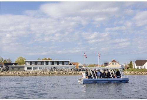 a group of people on a boat on the water at Hørby Færgekro in Holbæk