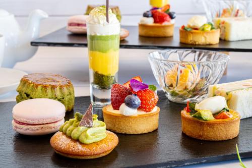 a table topped with different types of pastries and drinks at Holiday Inn Resort Shinano-Omachi Kuroyon by IHG in Omachi