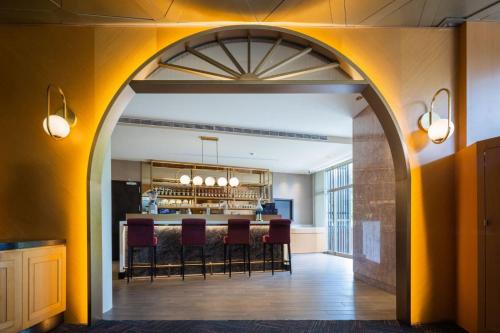 an archway leading to a bar with red chairs at Taoyuan Yuehua Hotel & Golf Club in Longtan