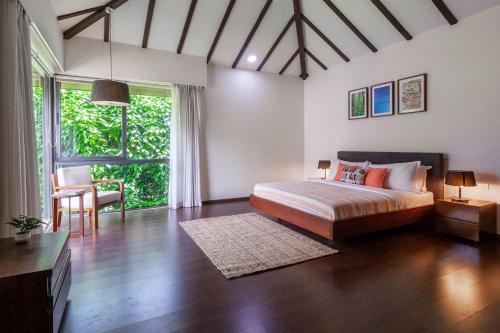 a bedroom with a bed and a large window at StayVista at Bella Orion with Pvt Pool- North Goa in Calangute