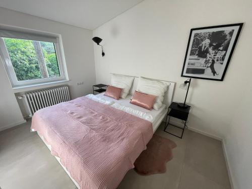 a bedroom with a bed with pink sheets and a window at The View in Ensch