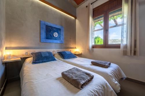 two twin beds in a room with two windows at El Clos 4 in Conesa